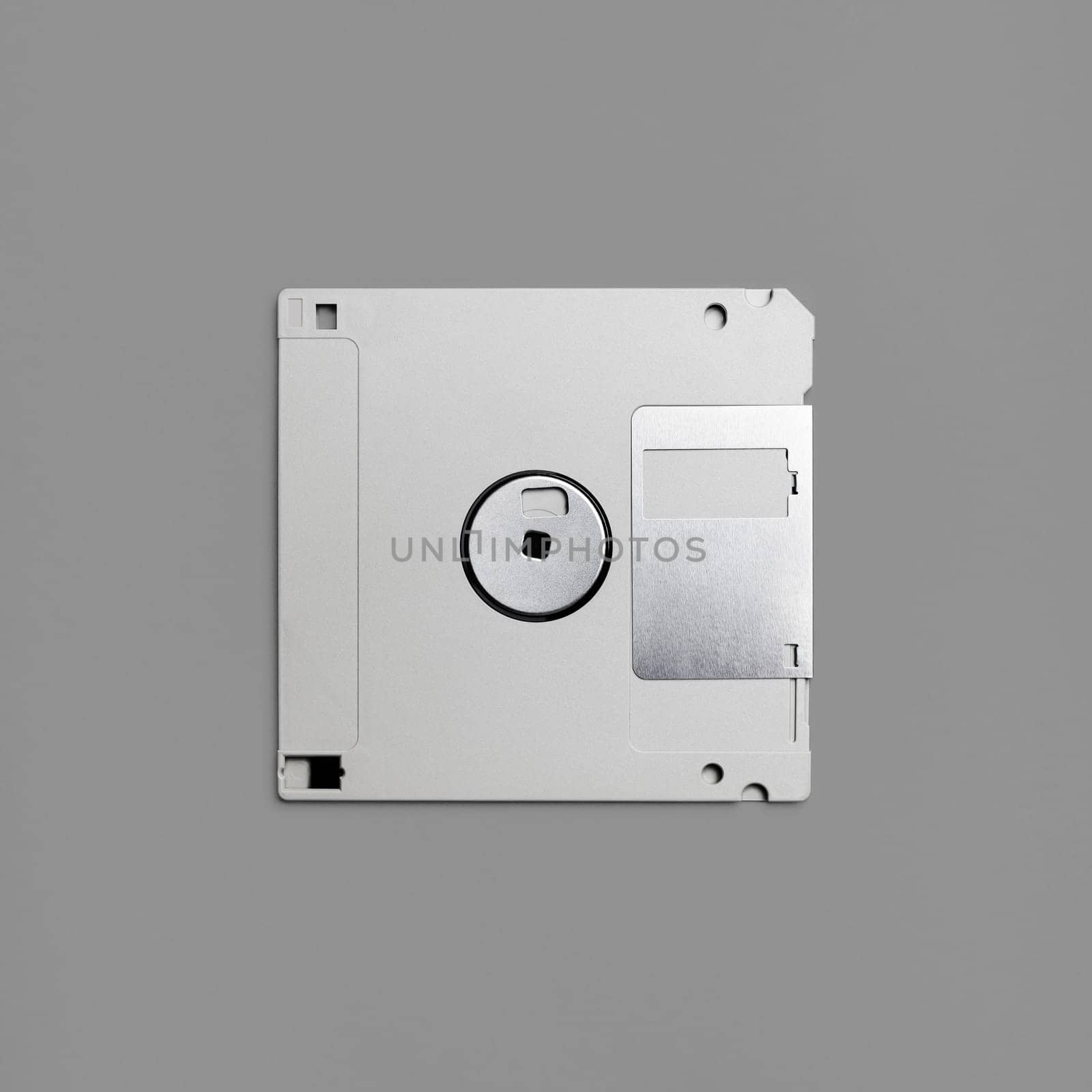 Floppy disk on gray paper background. Gray diskette. Top view. Flat lay.