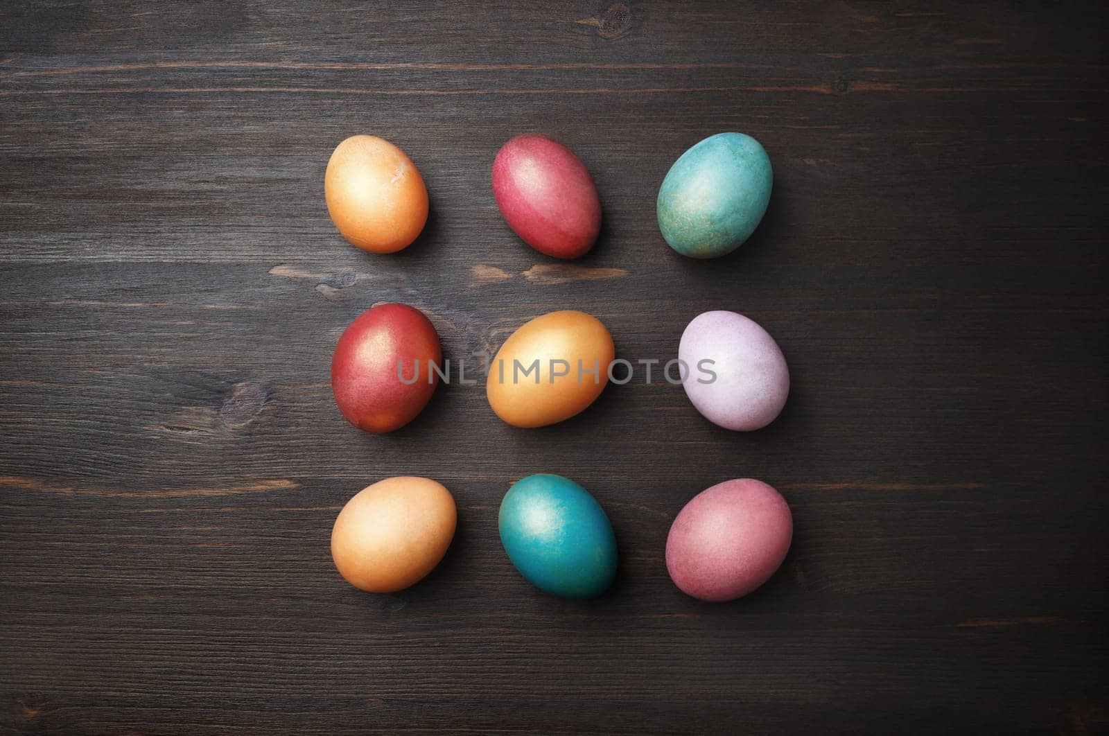 Colorful easter eggs on wood table background. Top view. Flat lay.