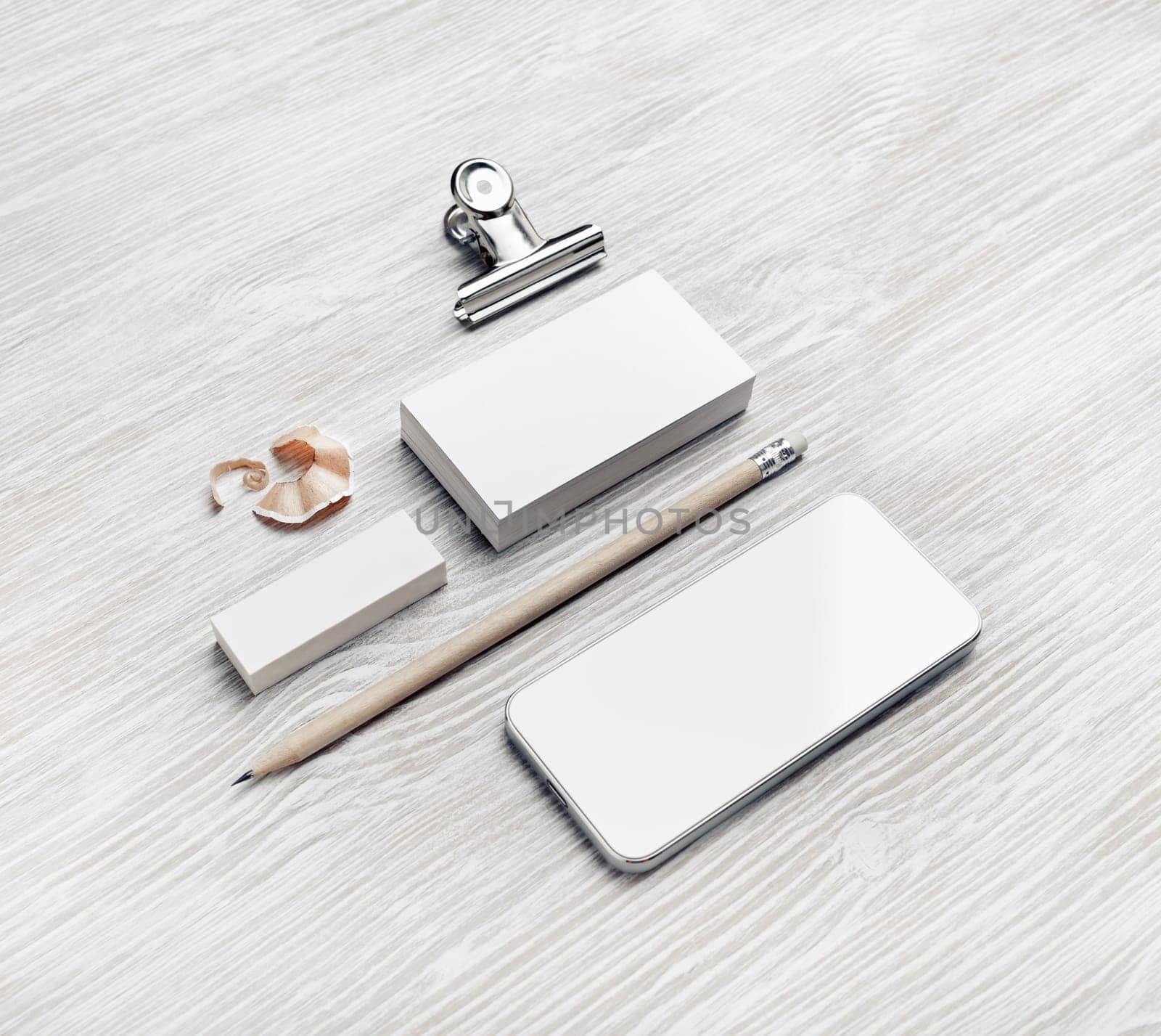 Blank business cards, smartphone, pencil and eraser on light wood table background.