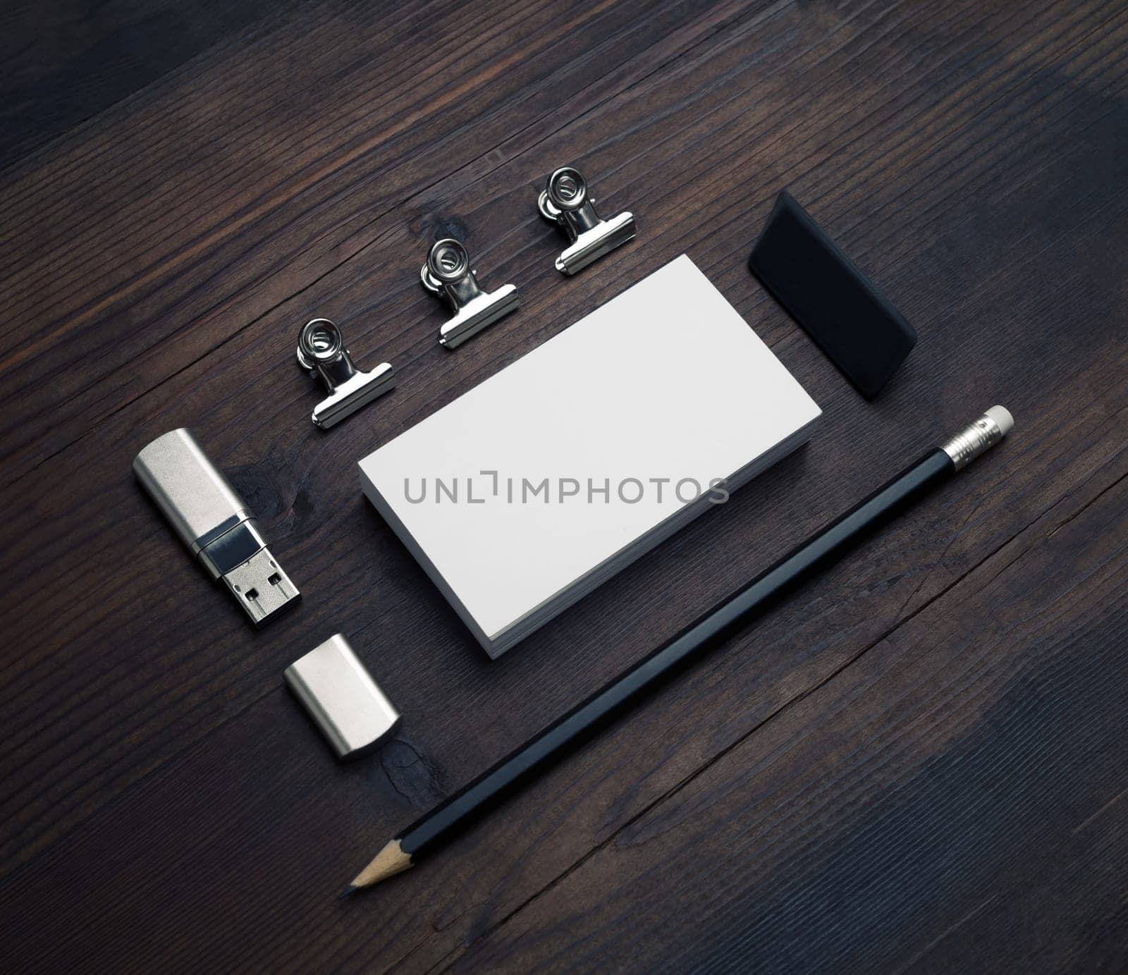 Blank business card, flash drive, pencil and eraser on wood table background. Responsive design mockup.