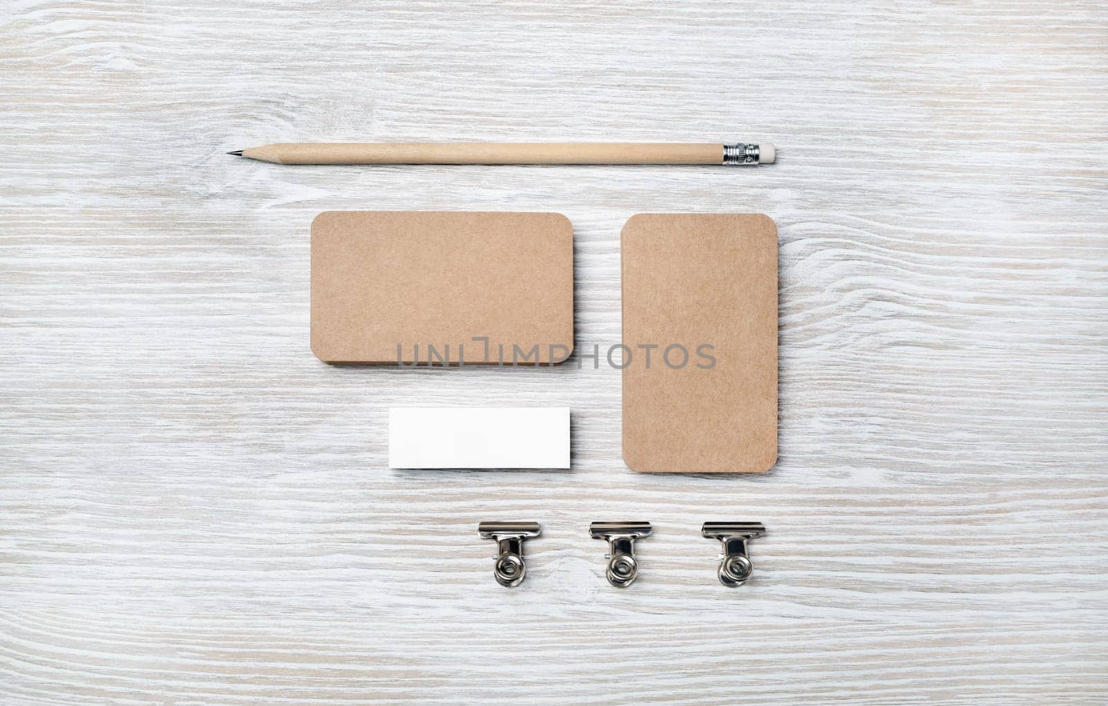 Blank vintage business cards, pencil and eraser on light wooden background. Branding ID mockup. Top view. Flat lay.