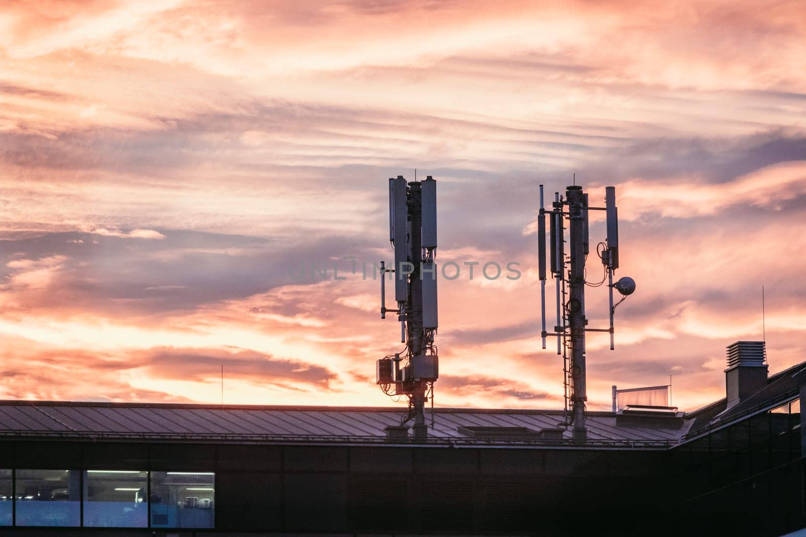 Transmitter antennas in the evening. Orange sky and clouds.