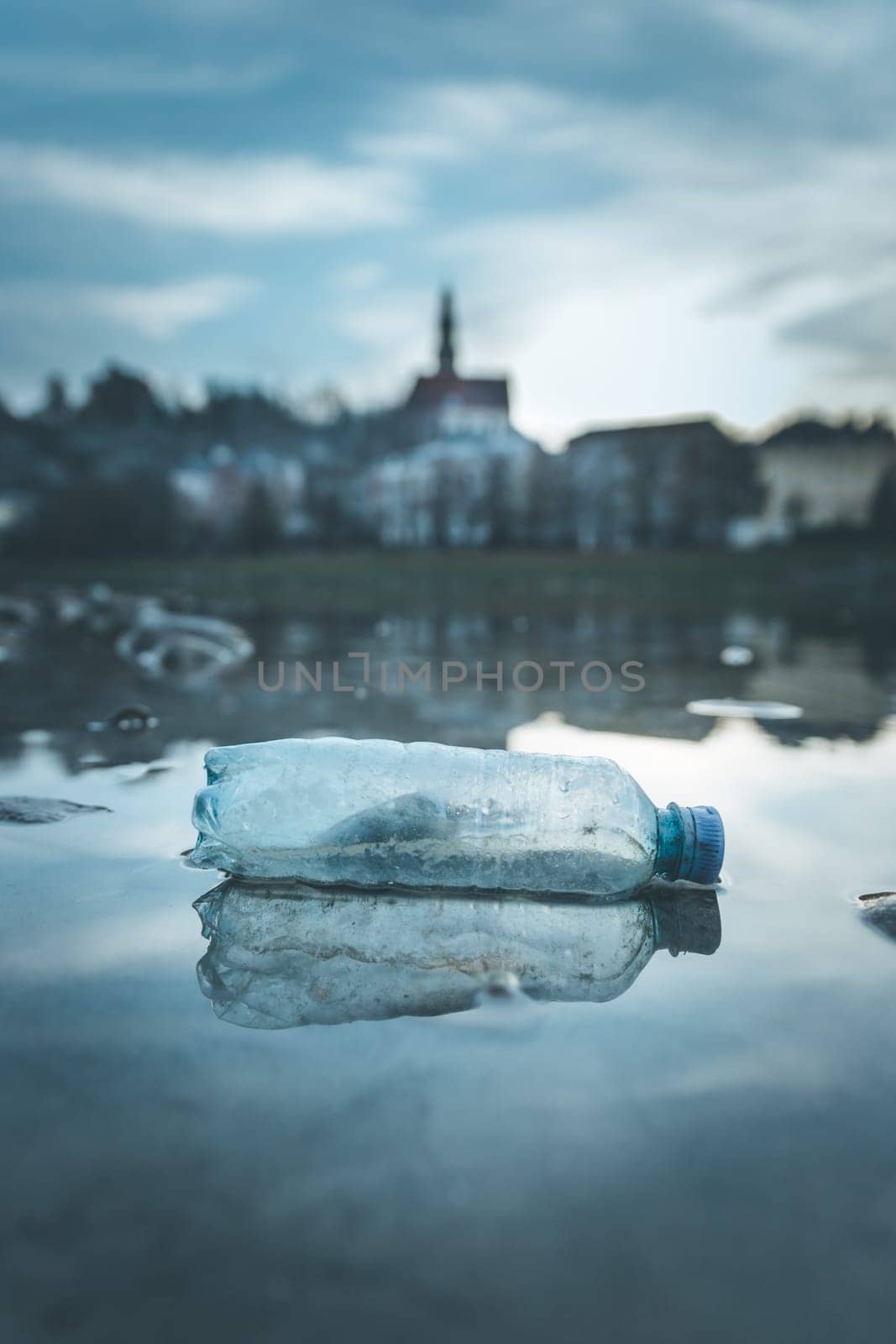 Environmental pollution: plastic bottle on the beach, urban city