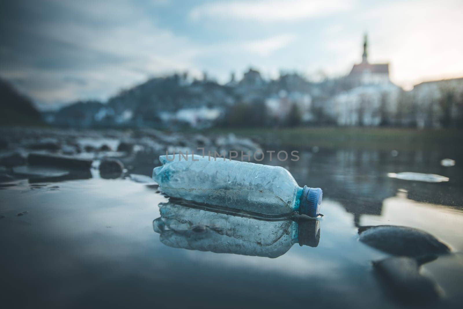 Environmental pollution: plastic bottle on the beach, urban city