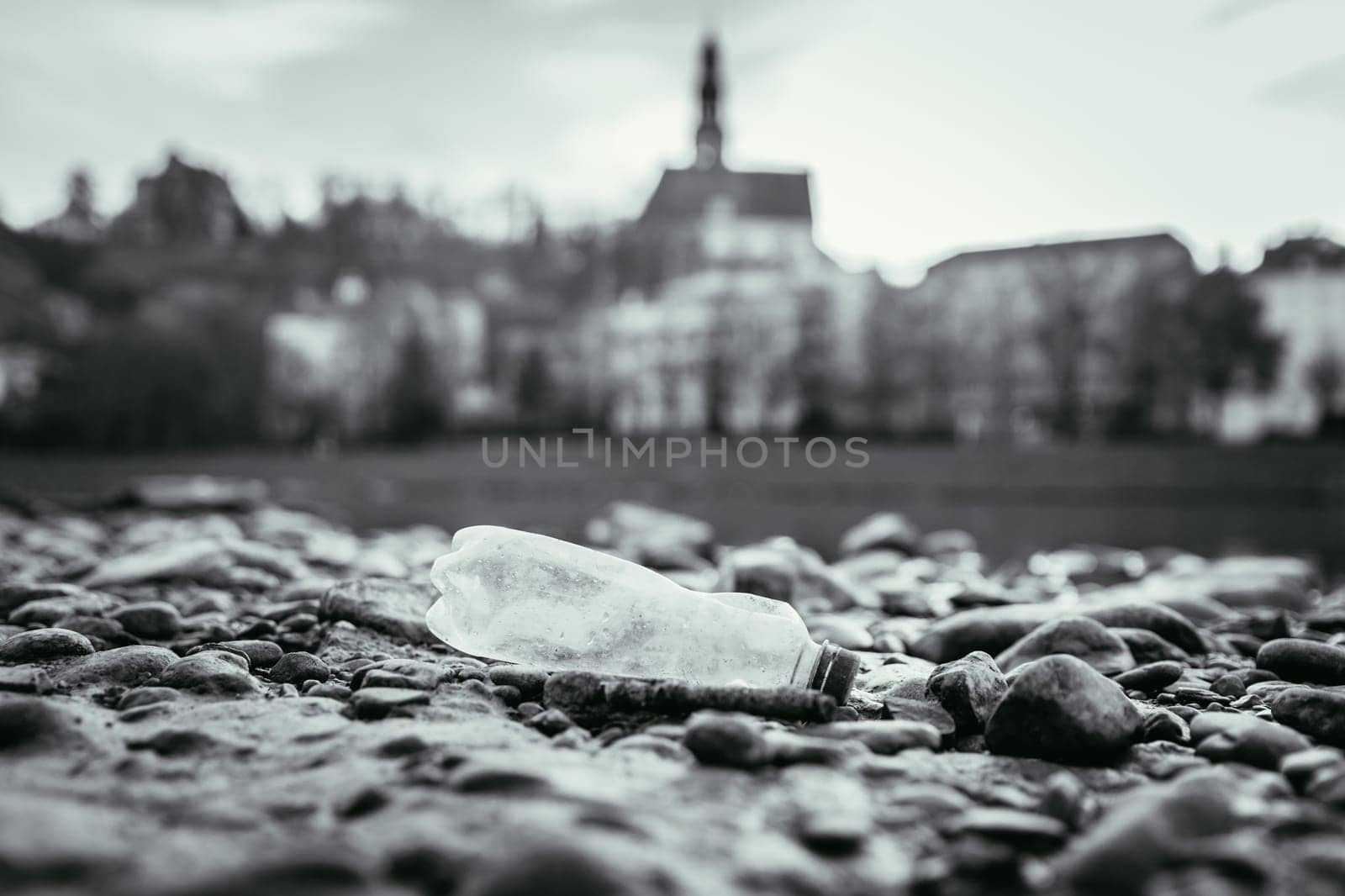Environmental pollution: plastic bottle on the beach, urban city