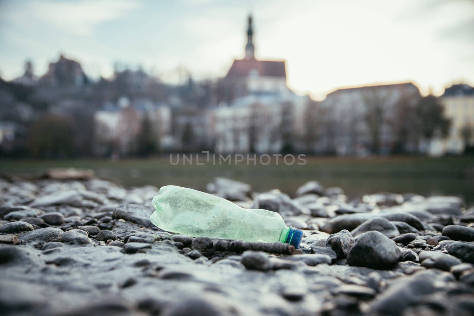 Environmental pollution: plastic bottle on the beach, urban city
