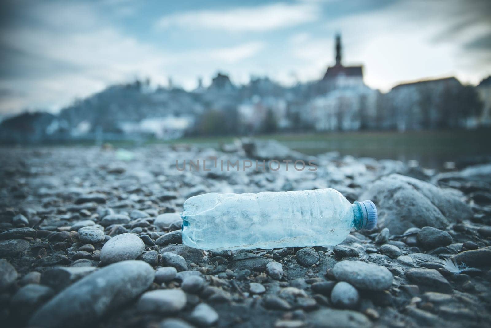 Environmental pollution: plastic bottle on the beach, urban city