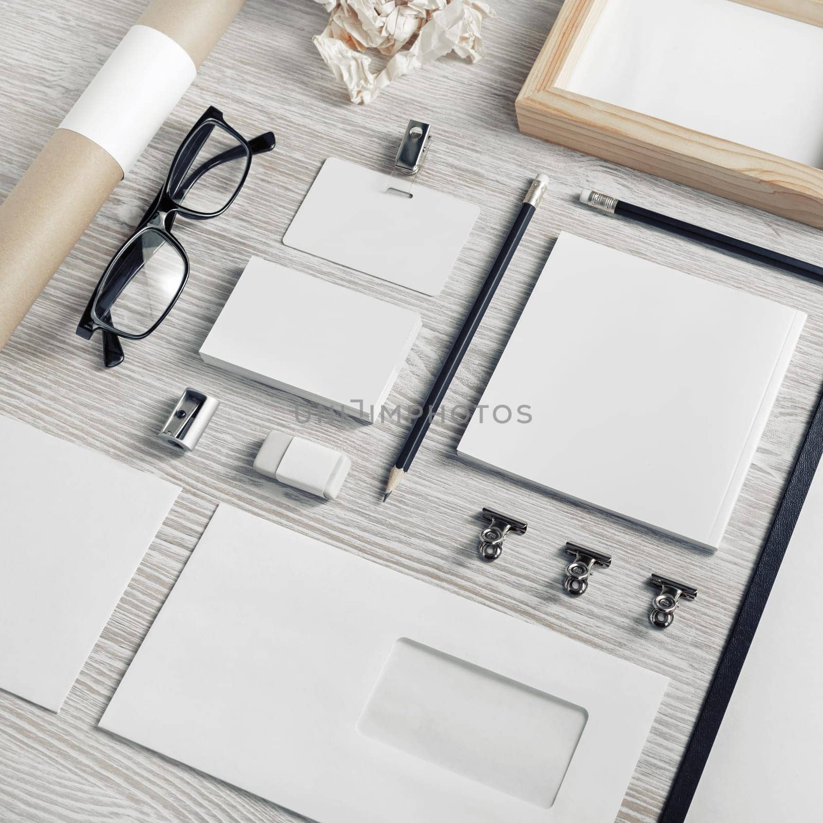 Blank business stationery set on light wood table background.