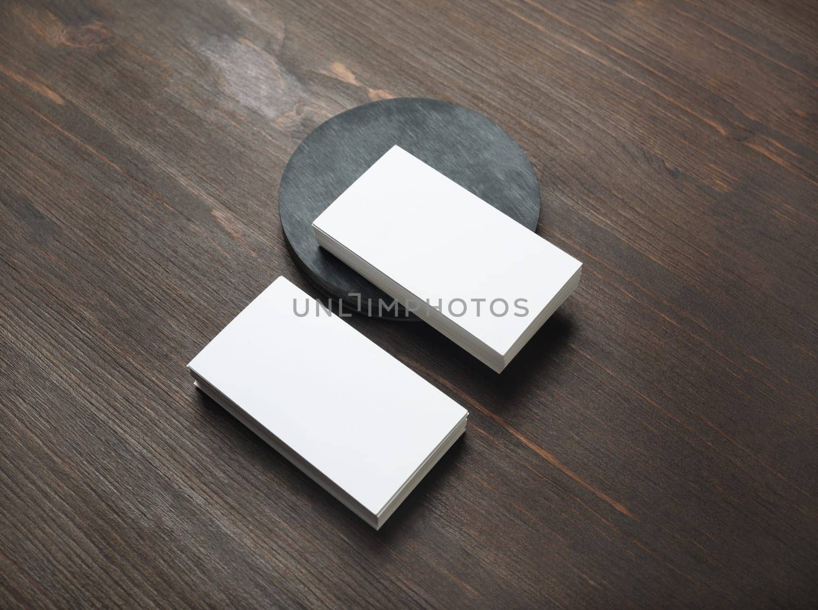 Photo of blank business cards on wood table background. Template for branding identity.