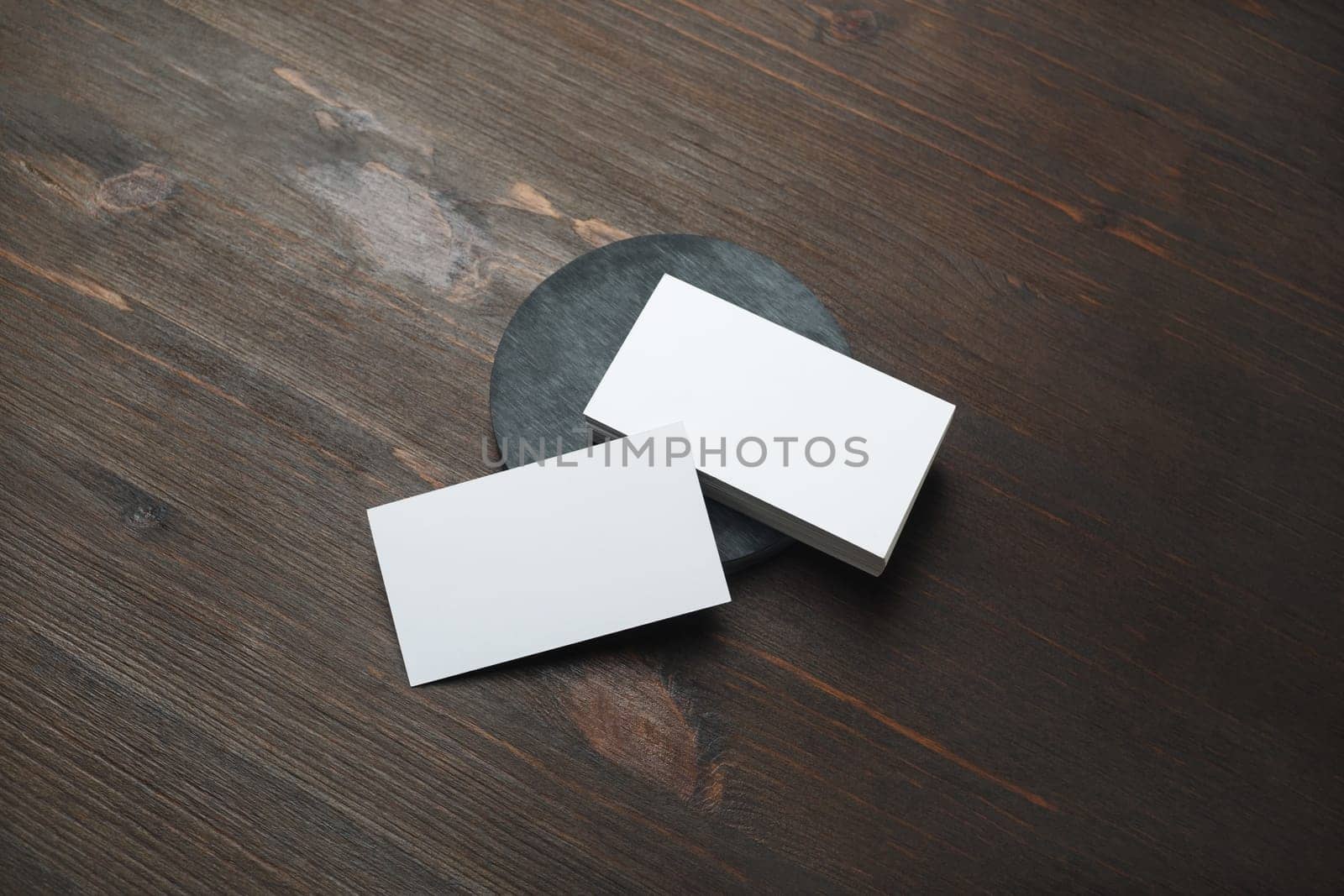 Blank white business cards on wood table background. Mockup for branding identity. Template for graphic designers portfolios.