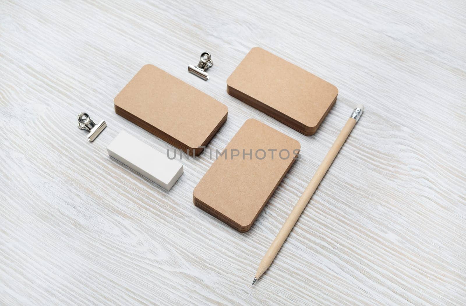 Branding mock up. Blank vintage business cards, pencil and eraser on light wood table background.