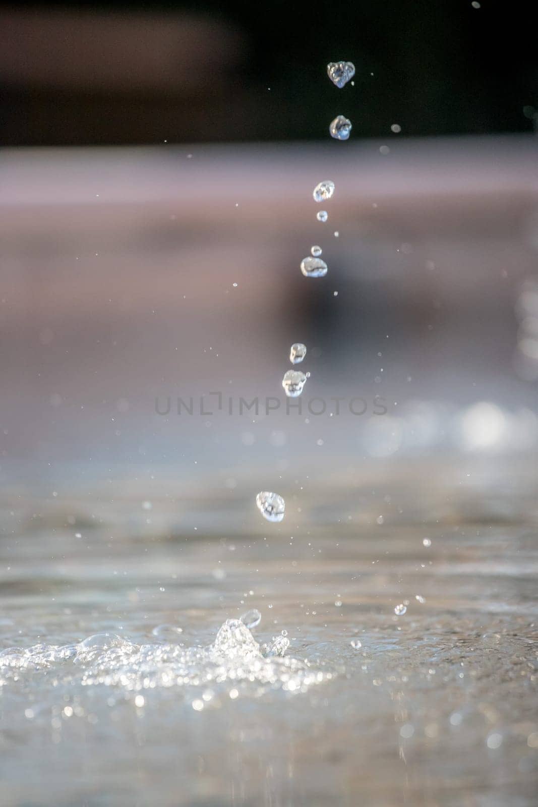 Fresh water drops falling into a well, summer time