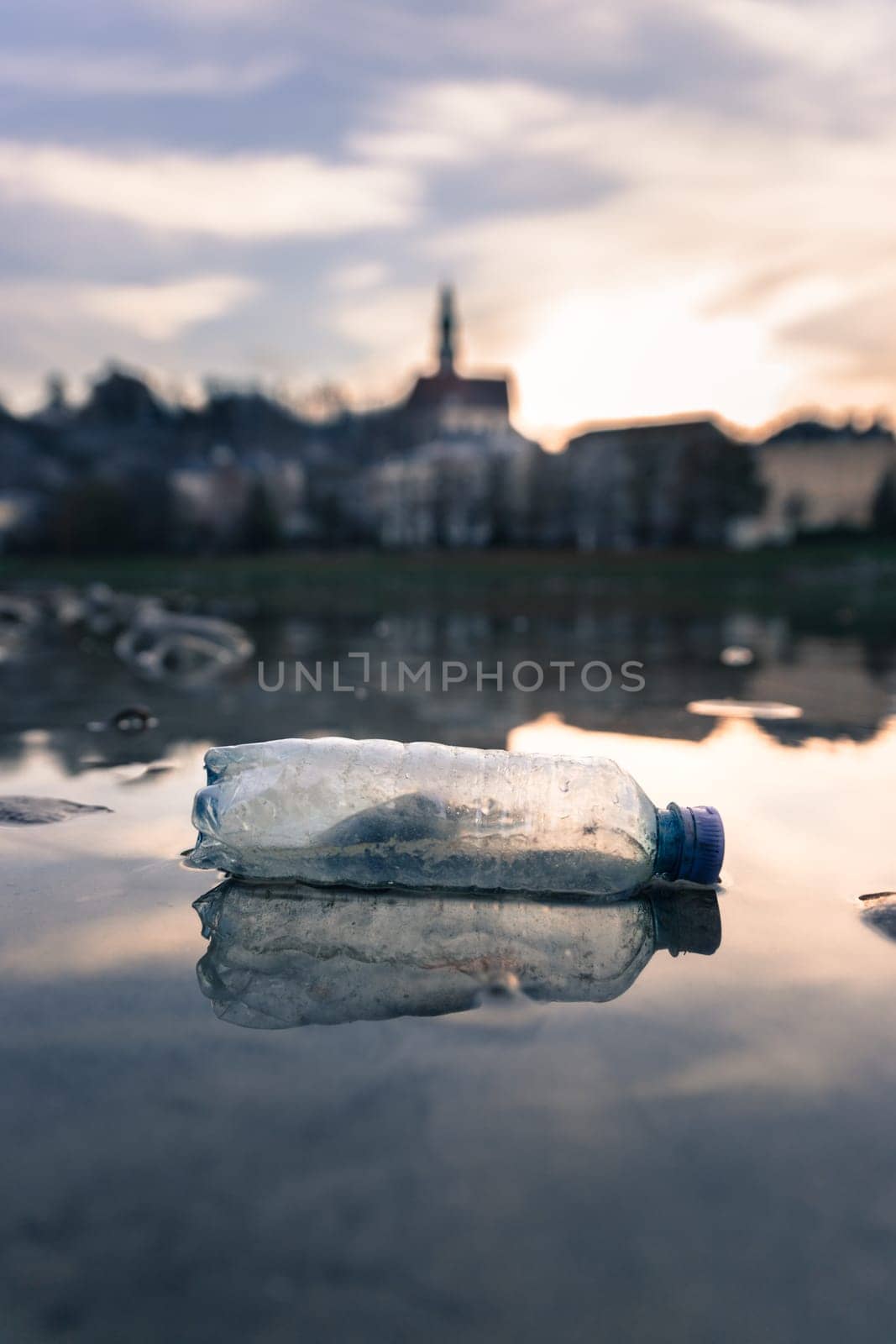 Environmental pollution: plastic bottle on the beach, urban city