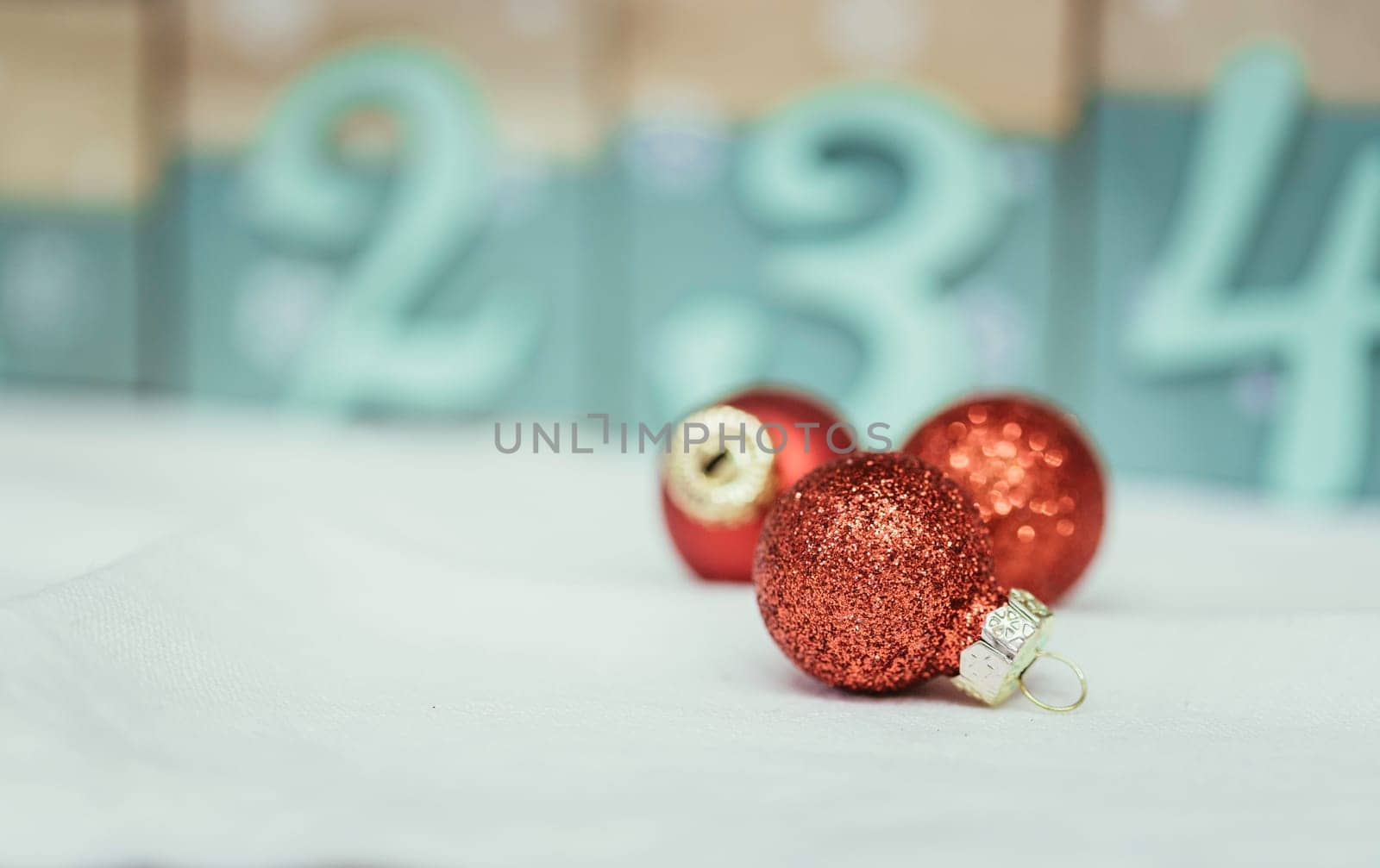 Christmas decoration: Close up of red Christmas baubles, advent calendar in the blurry background