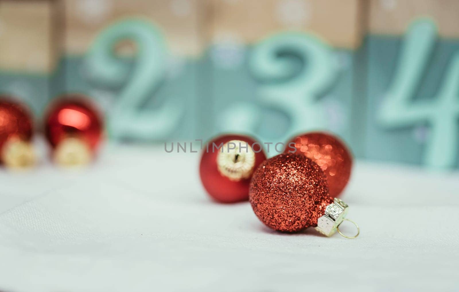 Christmas decoration: Close up of red Christmas baubles, advent calendar in the blurry background