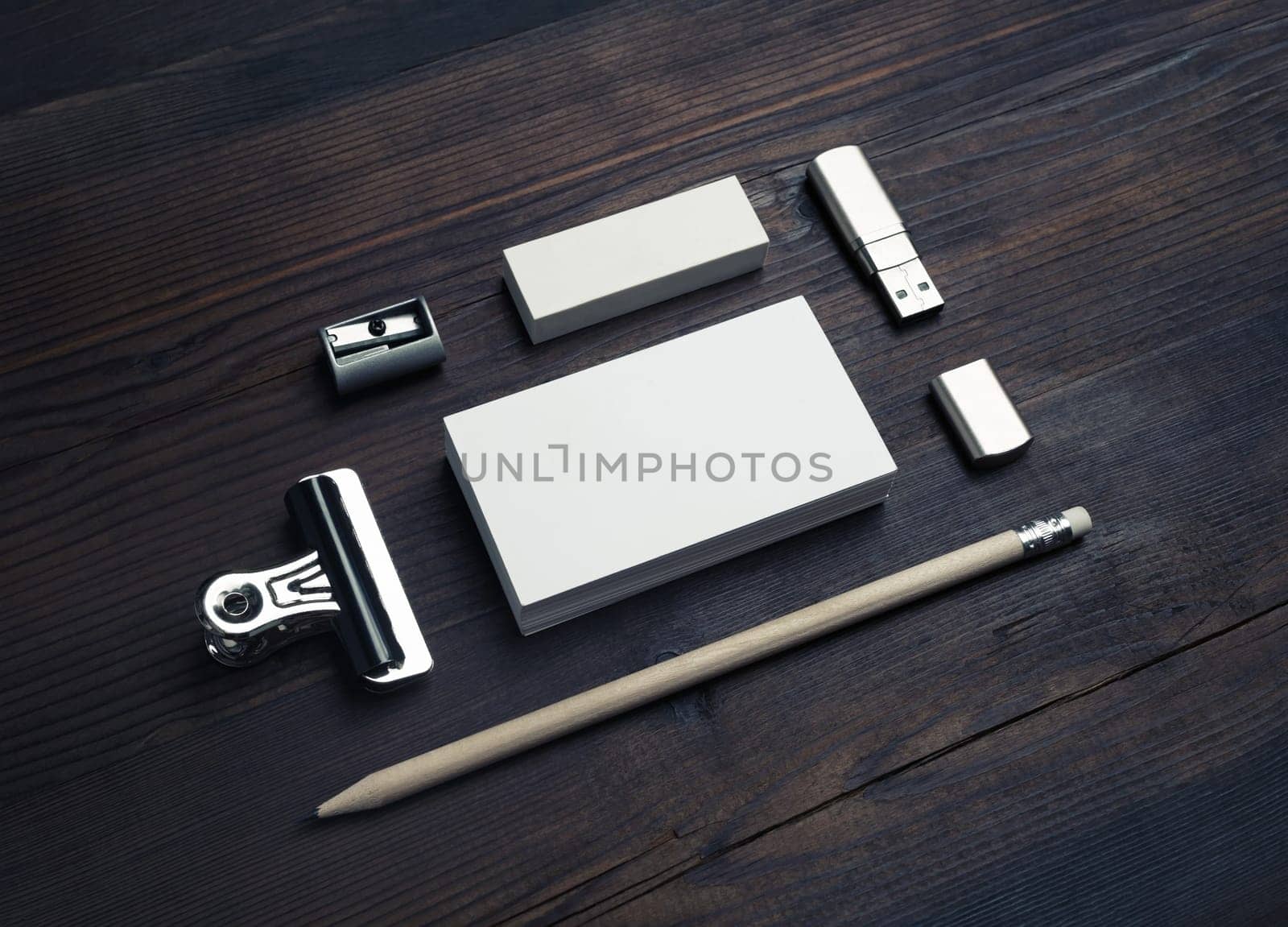 Blank stationery template on wood table background. Blank business card, flash drive, pencil, eraser and sharpener.