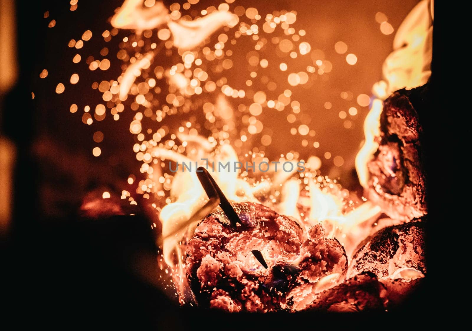 Blaze fire flame in oven, poking stick and sparks