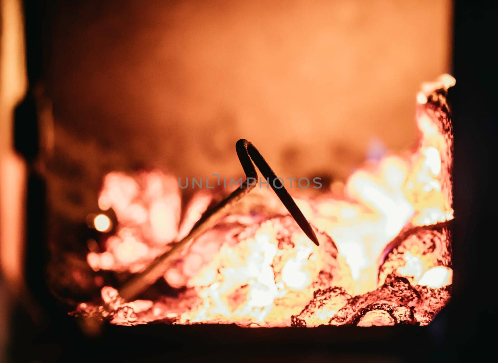 Blaze fire flame in oven, poking stick and sparks