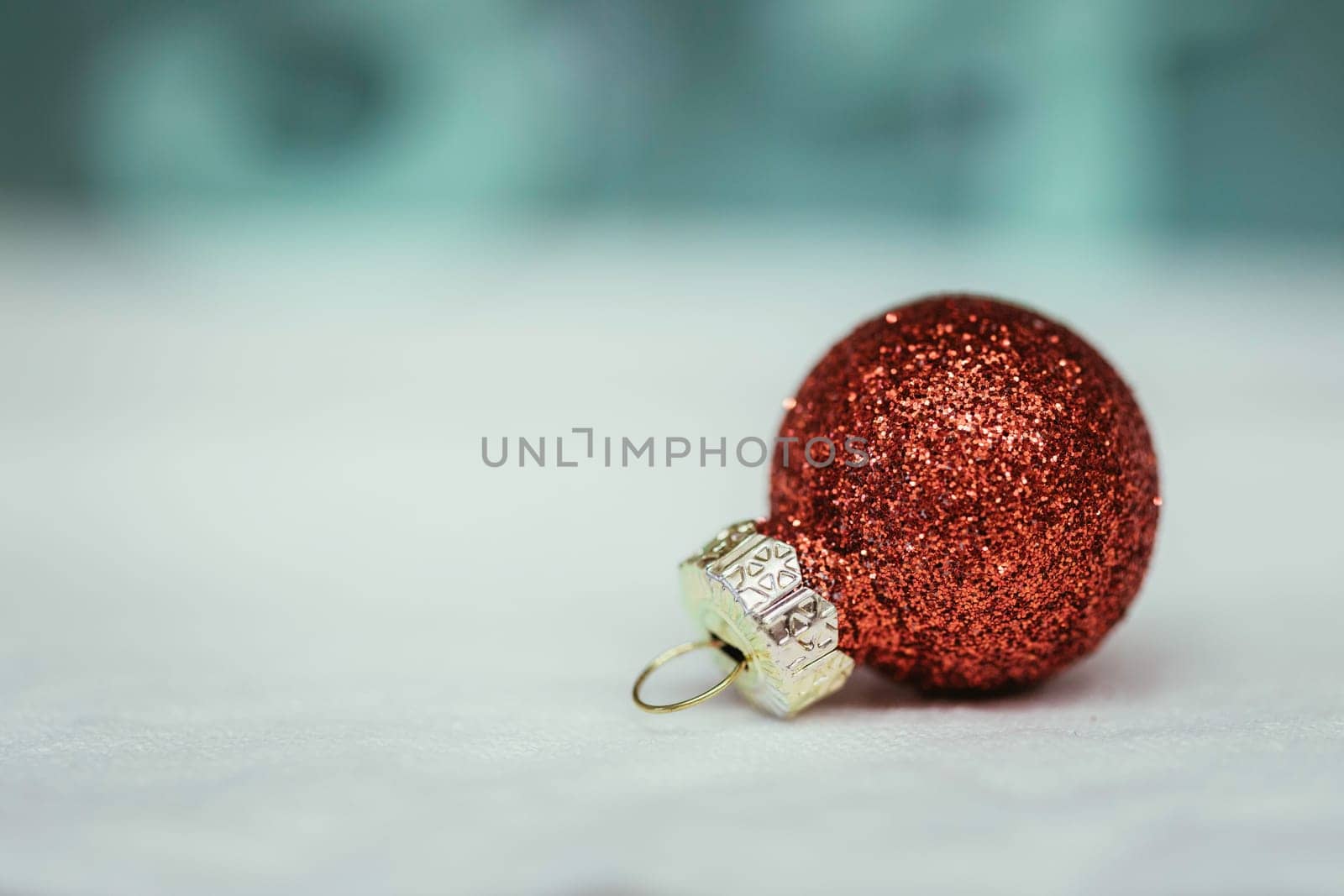 Christmas decoration: Close up of red Christmas bauble, lights in the blurry background