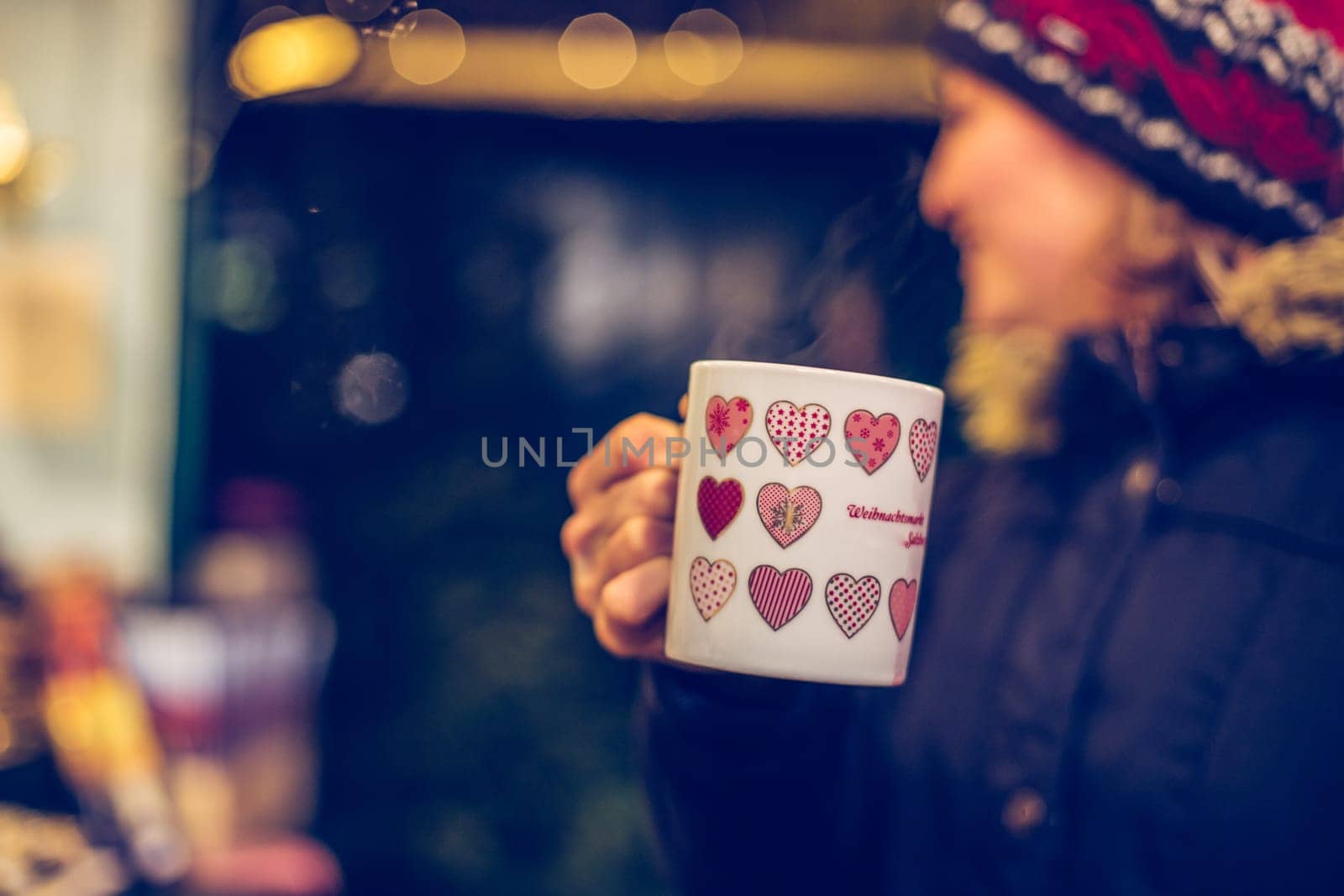 Girl is drinking mulled wine on the Christmas market, fun