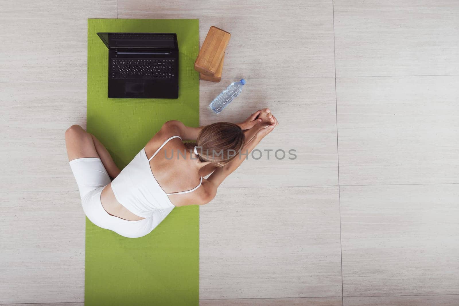 Attractive sportswoman doing workout online with laptop. Top view