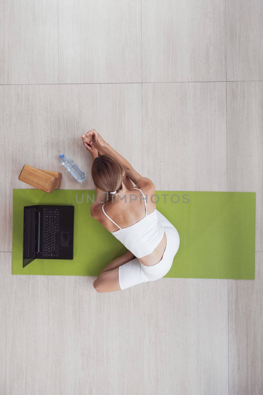 Attractive sportswoman doing workout online with laptop. Top view.