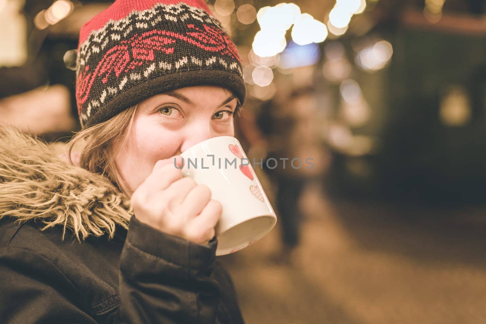 Girl is drinking mulled wine on the Christmas market, fun