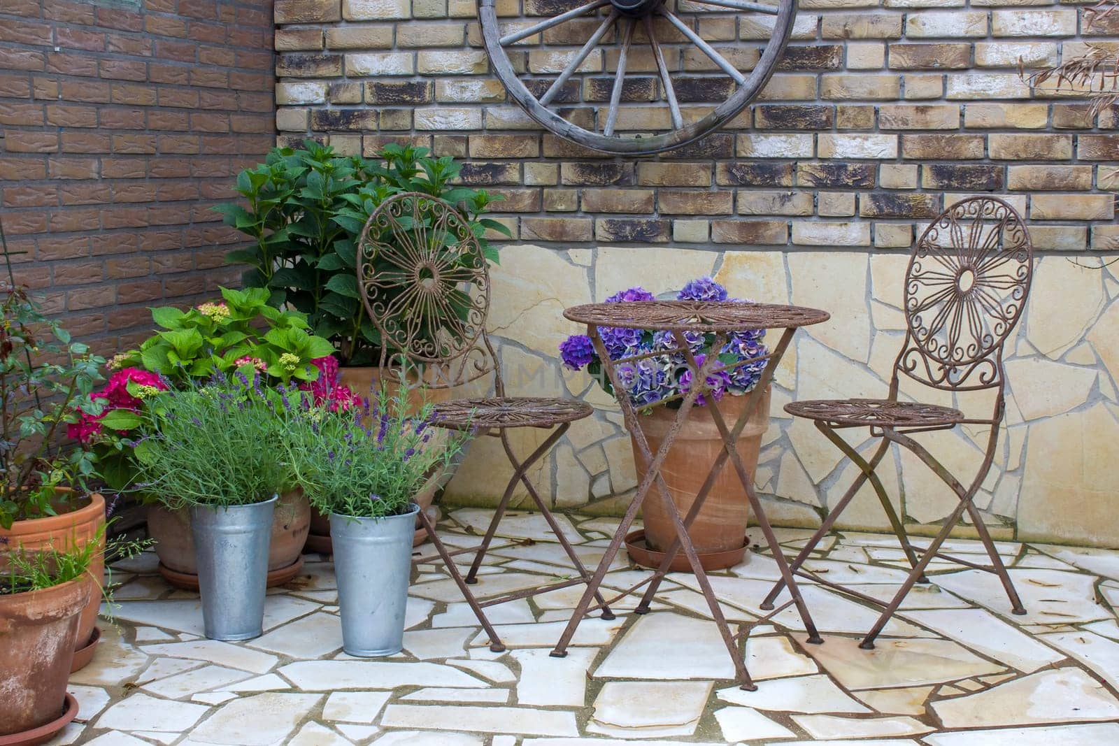 beautiful place in the garden in the mediterranean style, brick wall with grill and pots with flowers