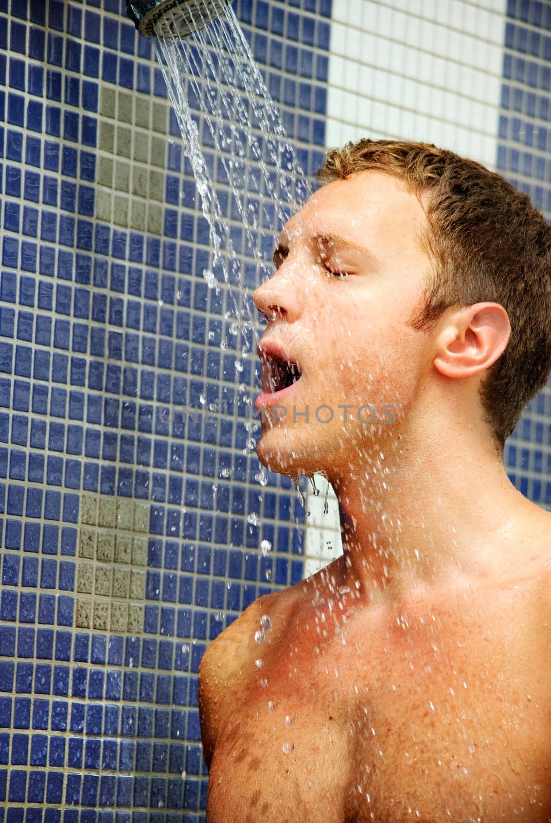 Portrait of handsome blond man under an outdoor shower