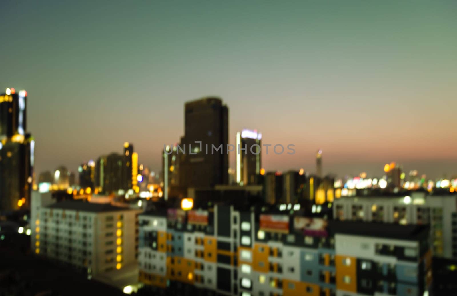 Blurred night city downtown lights with colorful buildings background at twilight time