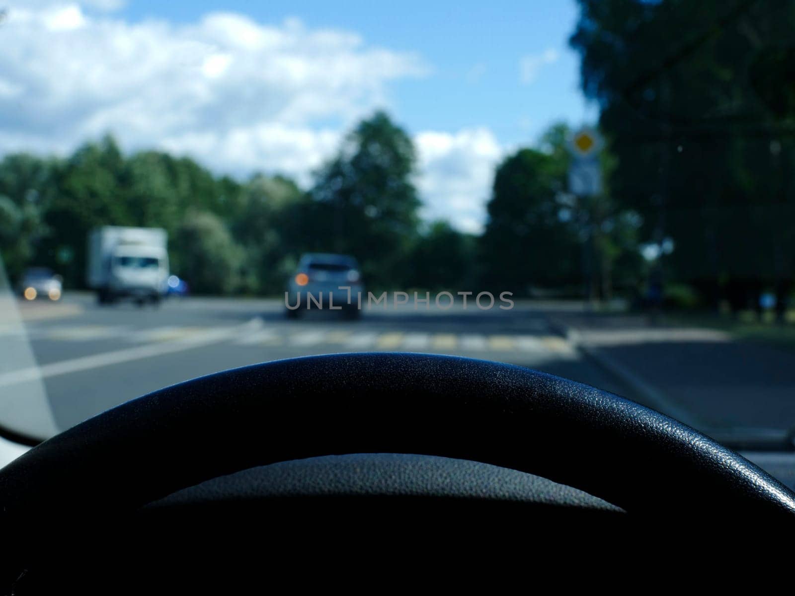 view from behind the steering wheel of a car first-person view