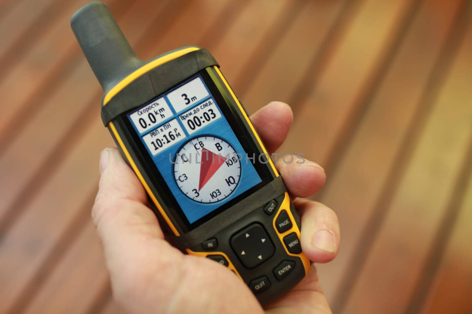 compass on the screen of a tourist  gps navigator in a man's hand