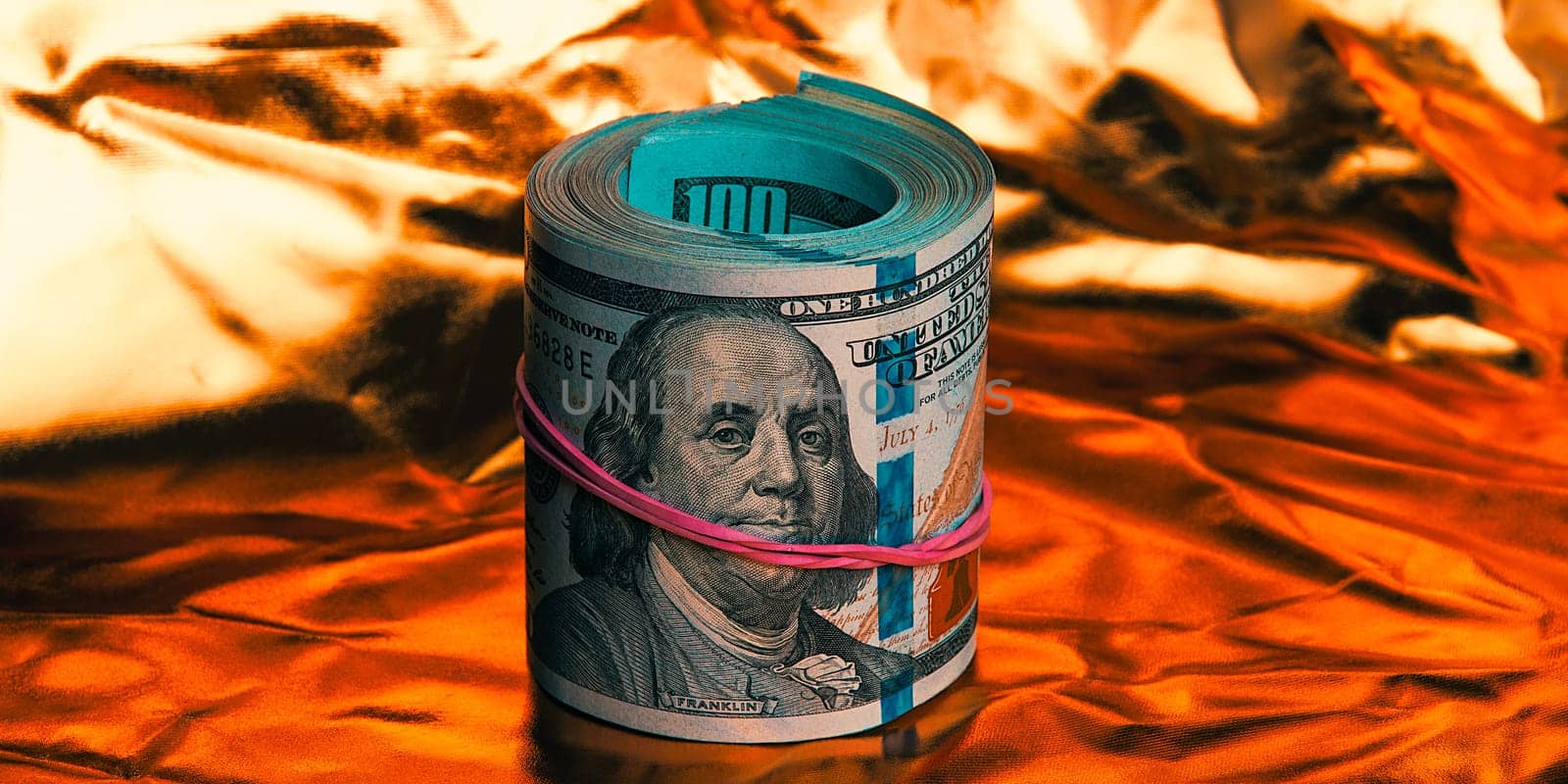 A roll of one hundred American dollars in close-up on a gold background. A big pile of cash dollars. One hundred dollar bills. Close-up, free space for captions and text.