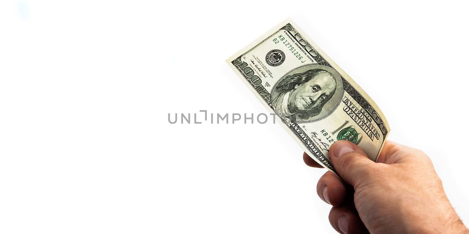 A hundred-dollar bill in his hand on a white background. Isolated. One hundred American dollars bill. One bill is dollars. The hand holds out the dollars. Place for logo, lettering, layout, layout.