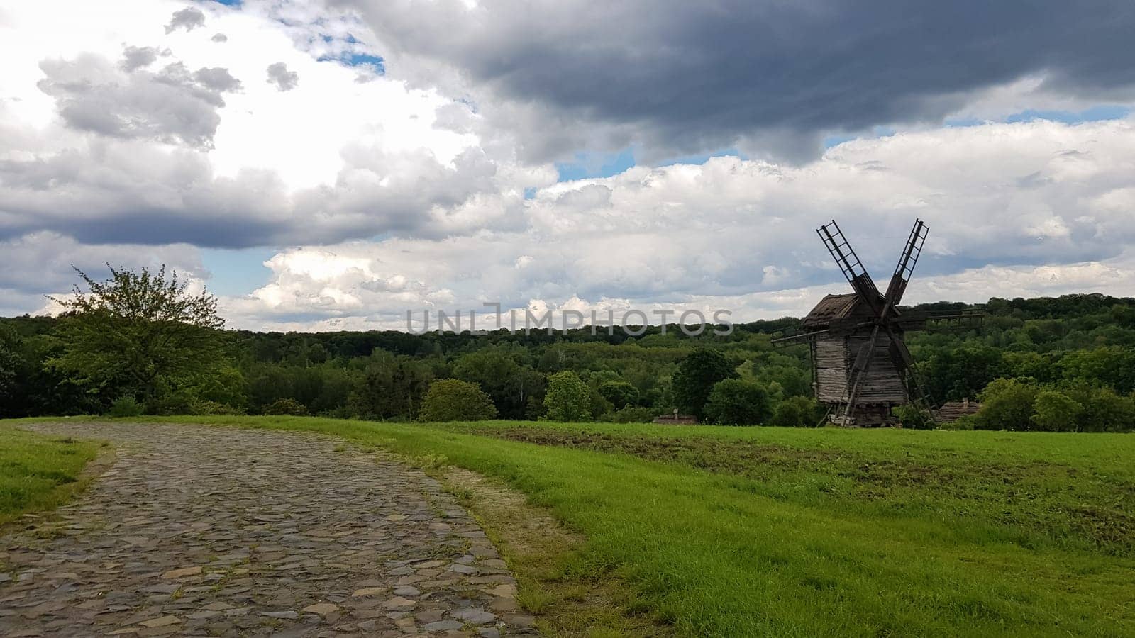 Ukraine, Kiev - June 11, 2020. Old Ukrainian wooden windmills of the XIX century. Summer outdoor landscape. Open-air museum of folk architecture and life, Pirogovo, Ukraine. Tourism and travel