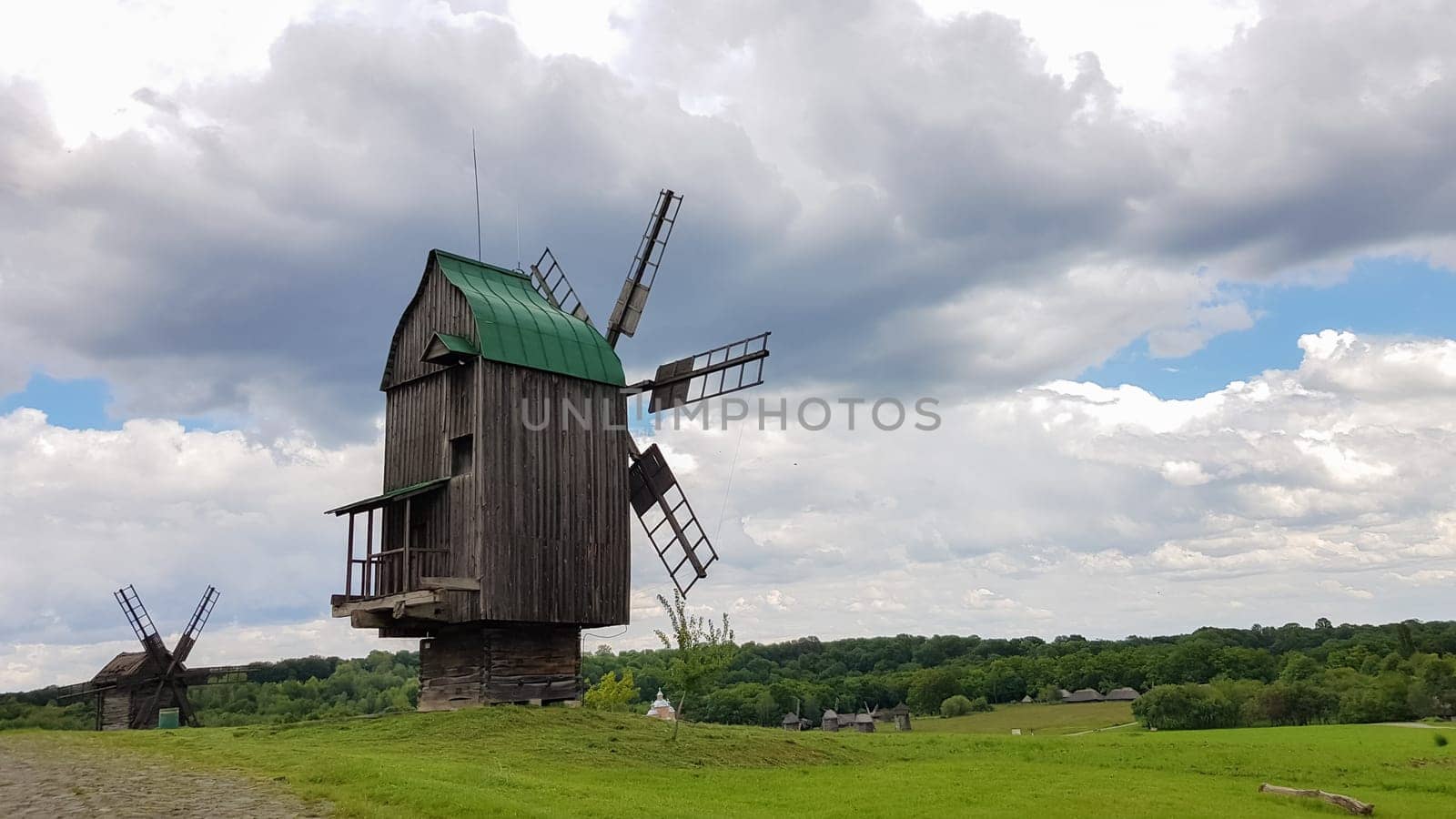 Ukraine, Kiev - June 11, 2020. Old Ukrainian wooden windmills of the XIX century. Summer outdoor landscape. Open-air museum of folk architecture and life, Pirogovo, Ukraine. Tourism and travel