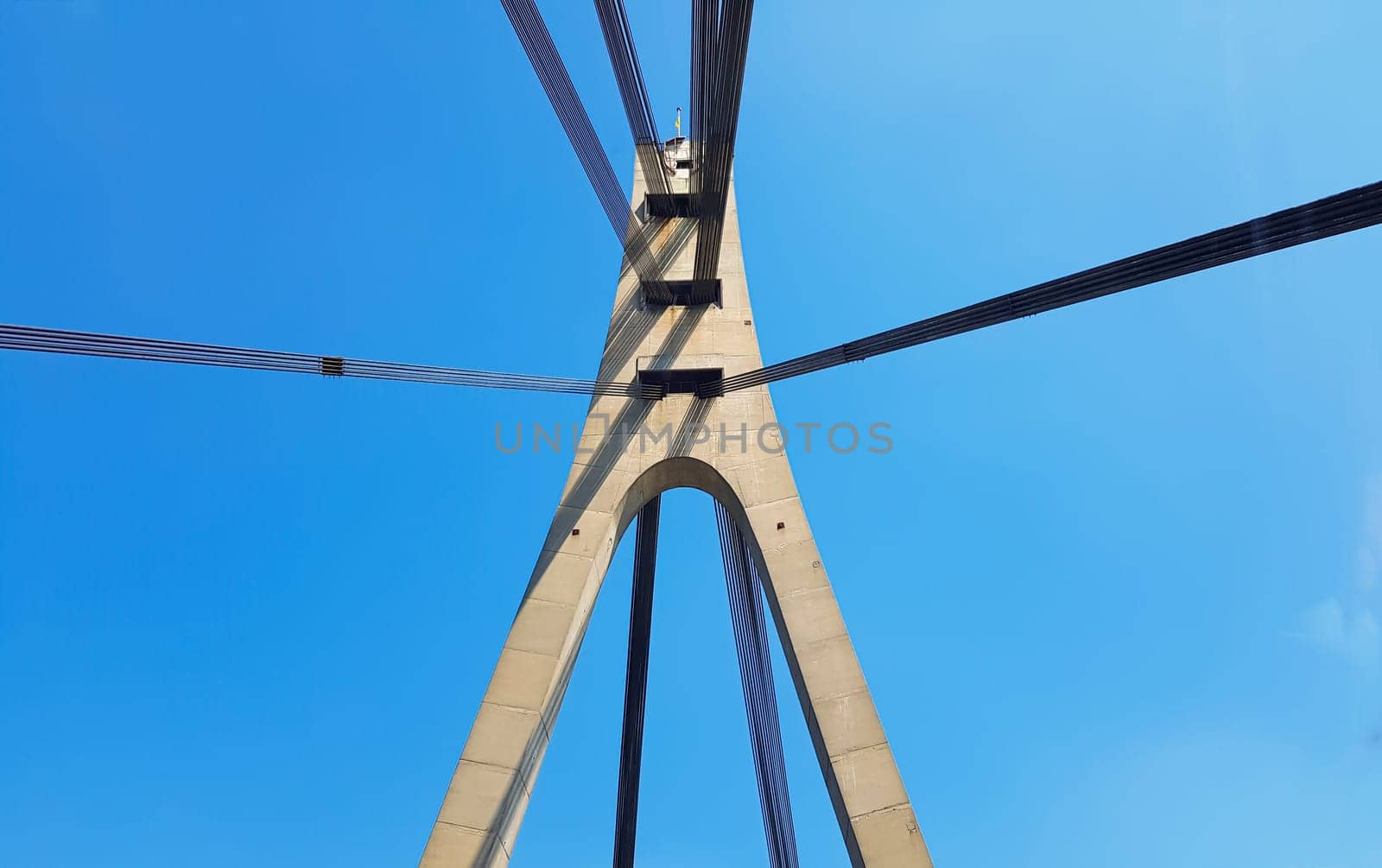 Ukraine, Kiev - August 20, 2019: A bridge across the river with pulling ropes. North bridge against the backdrop of a beautiful simple blue sky without clouds in Kiev. R. Dnieper. Ukraine. Scenery