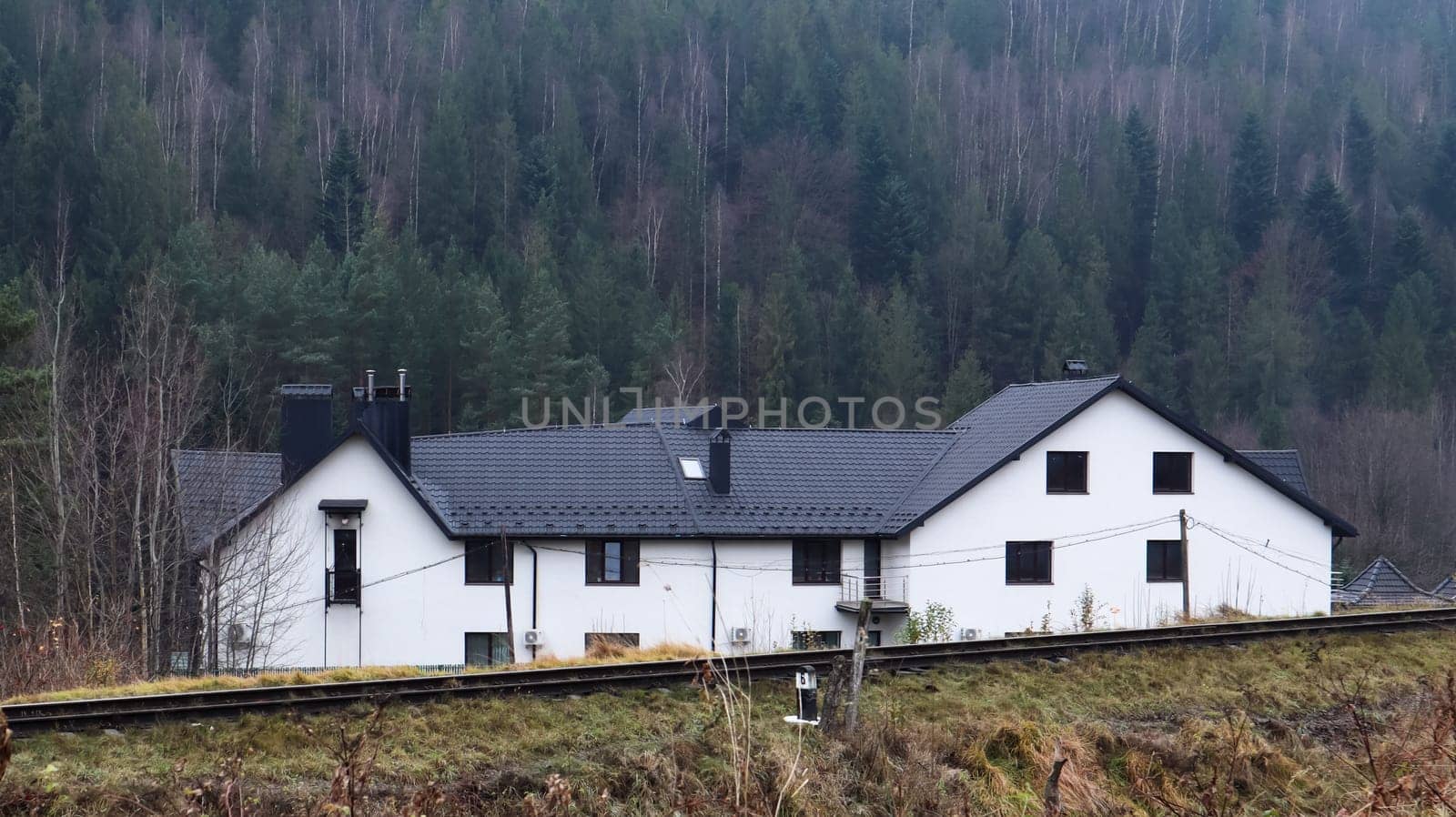 View of the picturesque village houses and cottages against the backdrop of mountains. The city of Yaremche among the Carpathians in the autumn afternoon. Ukraine, Yaremche - November 20, 2019.