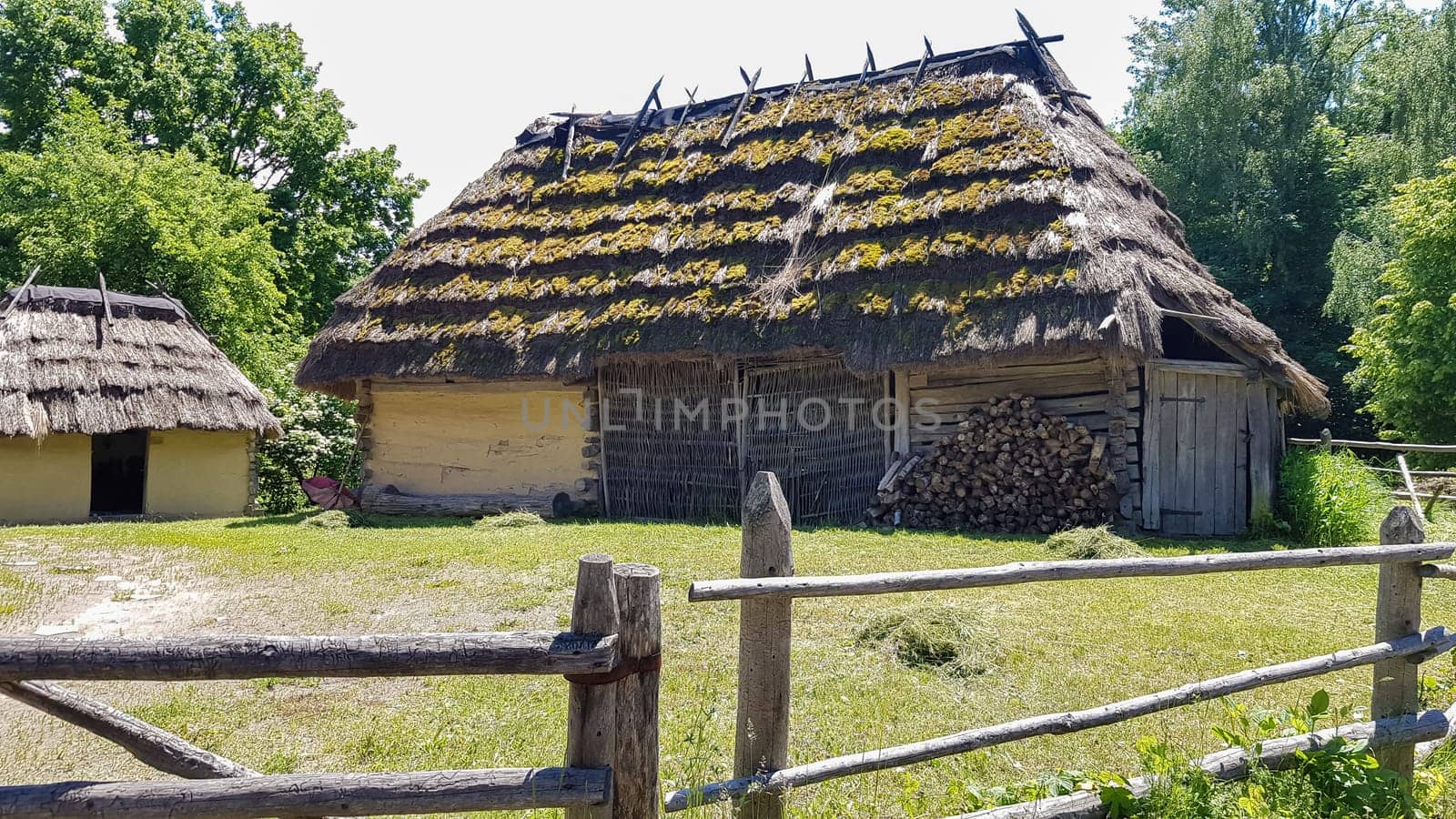Ukraine, Kiev - June 11, 2020. Old peasant Ukrainian house or barn in the summer with a thatched roof in the village. Pirogovo Museum in the open air of different regions of Ukraine