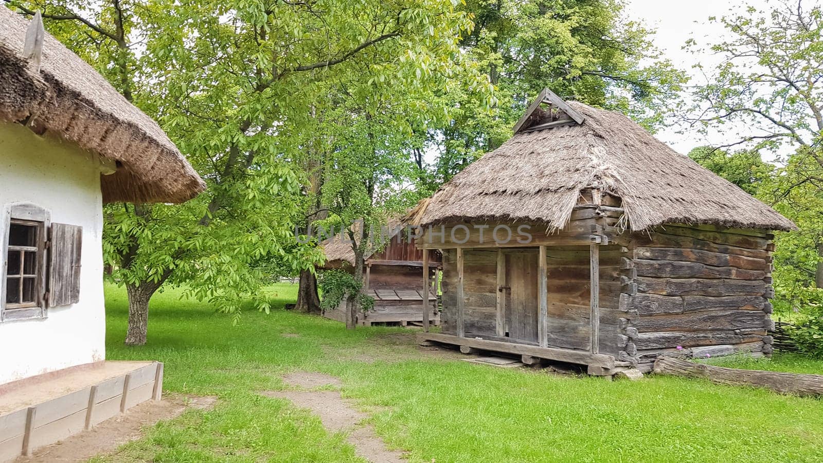 Ukraine, Kiev - June 11, 2020. Old peasant Ukrainian house or barn in the summer with a thatched roof in the village. Pirogovo Museum in the open air of different regions of Ukraine