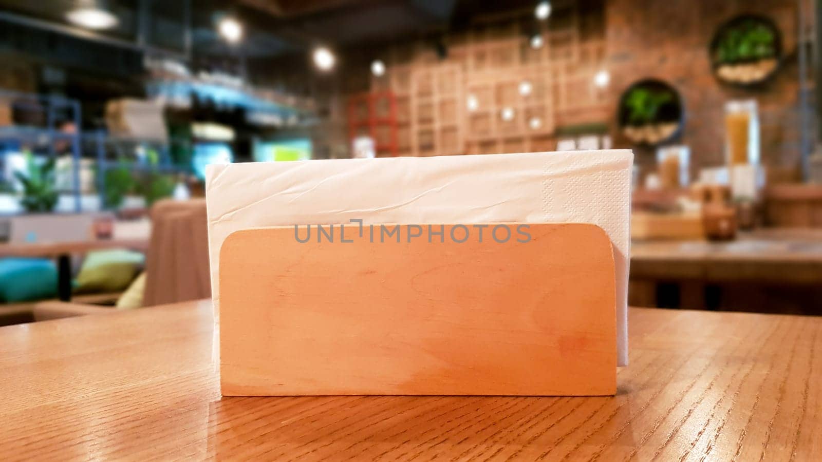 Ukraine, Kiev - September 1, 2019: A table in a cafe or restaurant. White napkins in a wooden napkin holder, panoramic view.