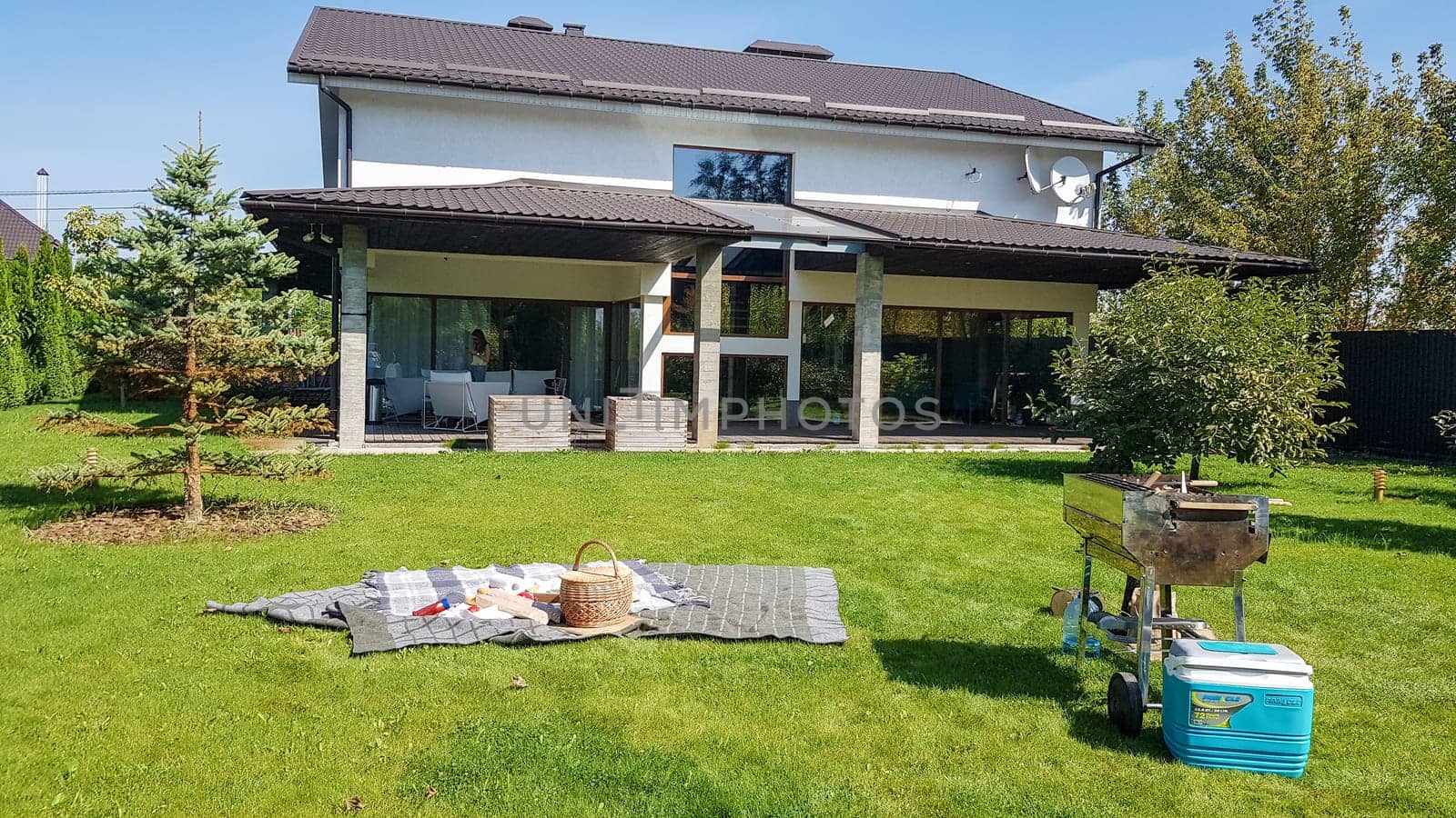 Ukraine, Kiev - September 24, 2019: facade of a new modern Australian-style home. Picnic with a barbecue in the courtyard of a large house on a green lawn. Luxury Villa Resort Interior.