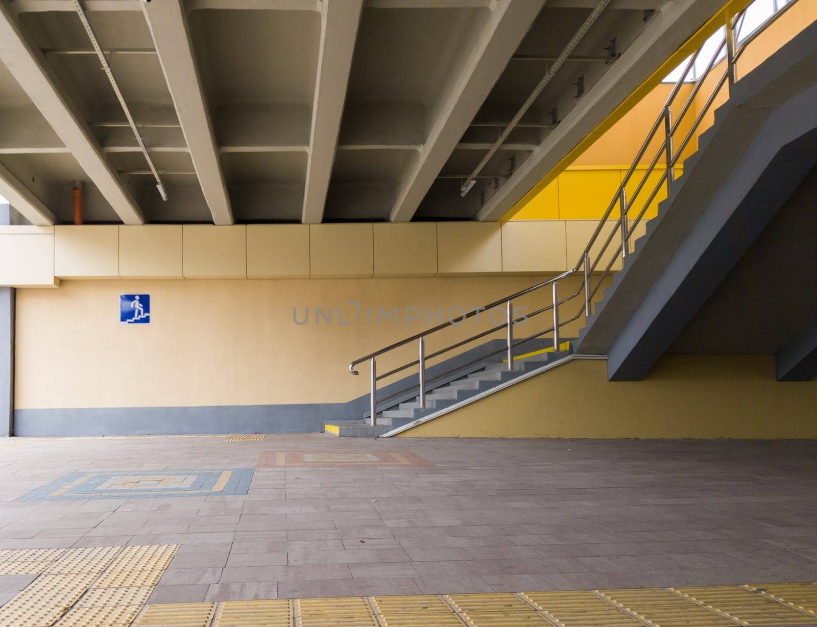 Ukraine, Kiev - September 26, 2019: The sign is an underground pedestrian crossing at the entrance to the underground passage. Empty yellow underground pedestrian crossing. Blue square transition sign in the city.