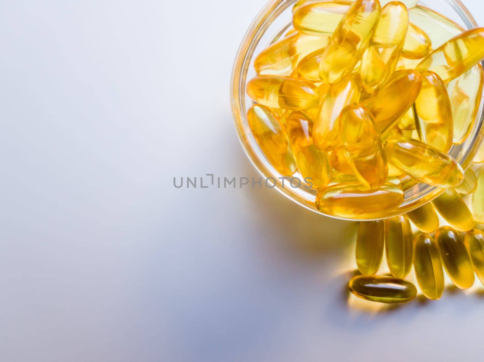 Fish oil capsules on a glass plate. A lot of vitamin omega 3 on a white background. Close-up, top view, high resolution product. Metabolism in the body. The body of calcium. A quick way to lose weight.