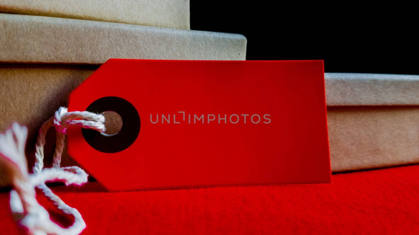 Cardboard boxes with a tag. Brown packing box with blank label and copy space on red backdrop.