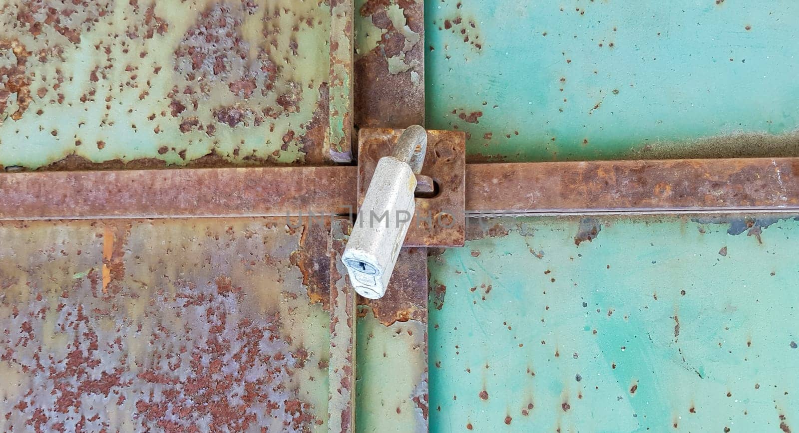 metal door with lock, texture and background. Background texture of an iron padlock on a rusty metal gate