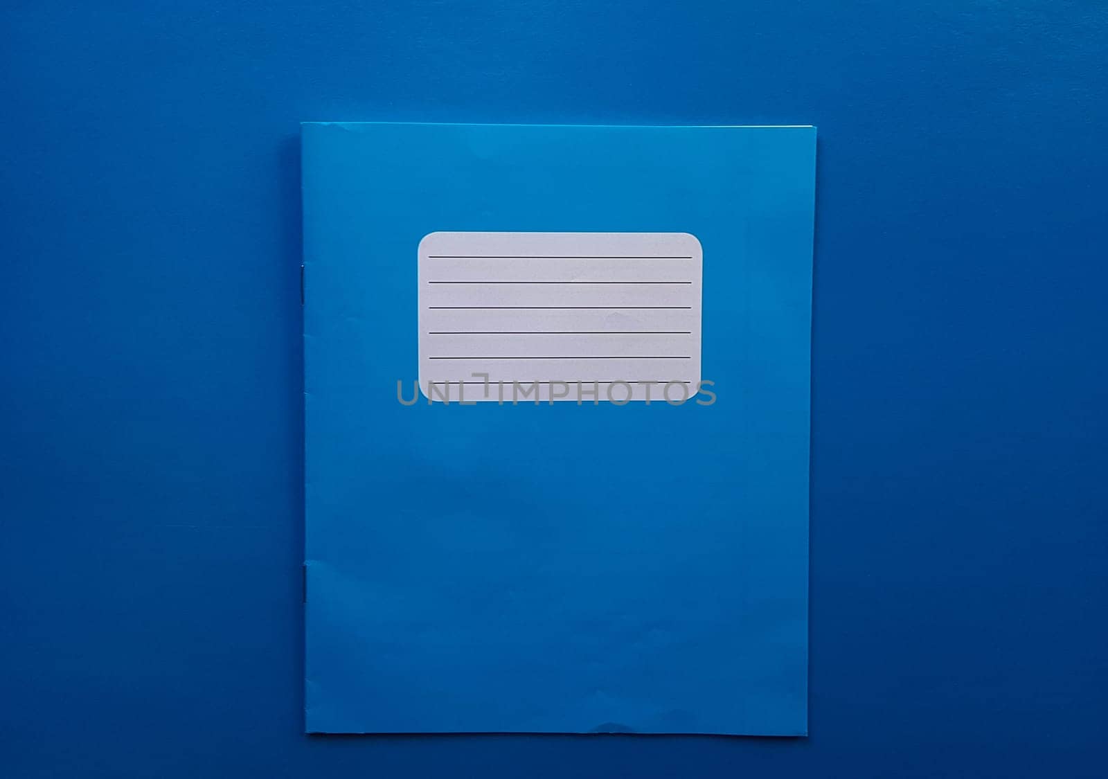 Old copybook on a blue background. School notebook, preparation for September 1 and the new school year.