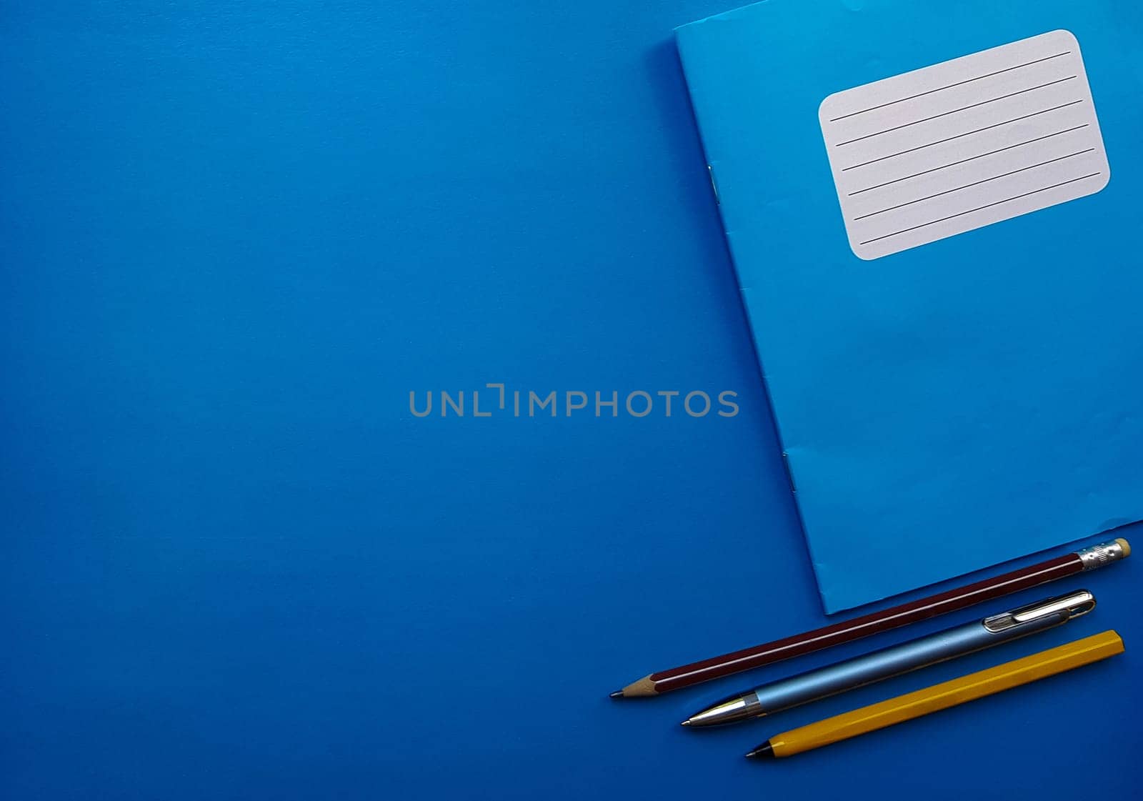 Old copybook on a blue background. School notebook, preparation for September 1 and the new school year.