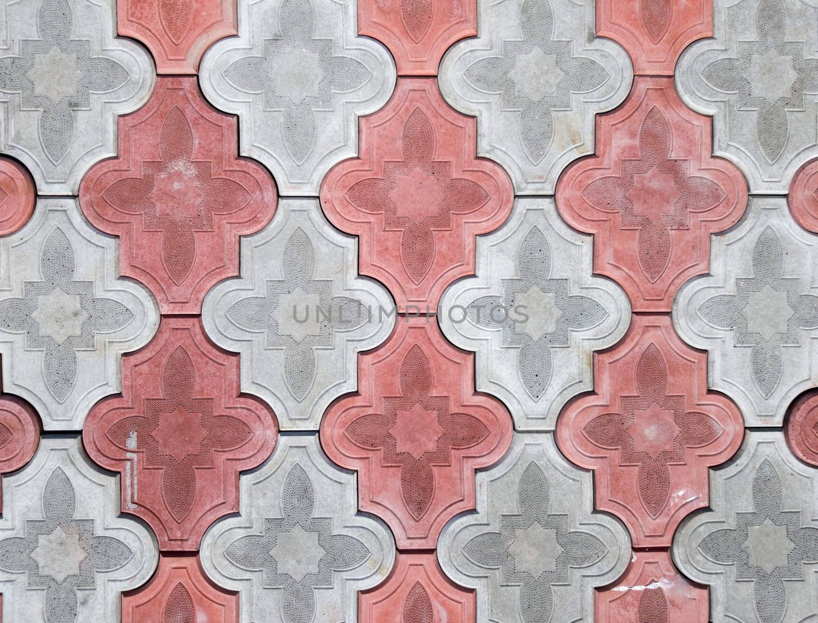 concrete coating of gray and red colors. Sidewalk of gray and pink pavers close-up. Texture, background from curly gray-orange stone. Top view on the sidewalk.
