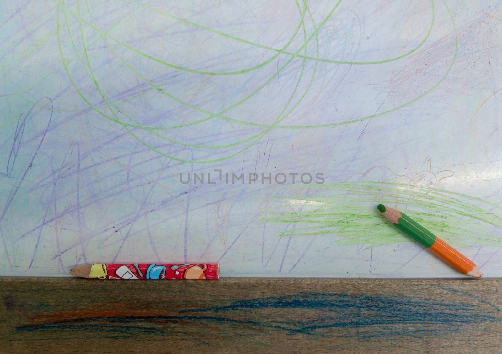 color pencils with drawn colored lines isolated on white background. Top view. Hand drawn scribble smears on paper.